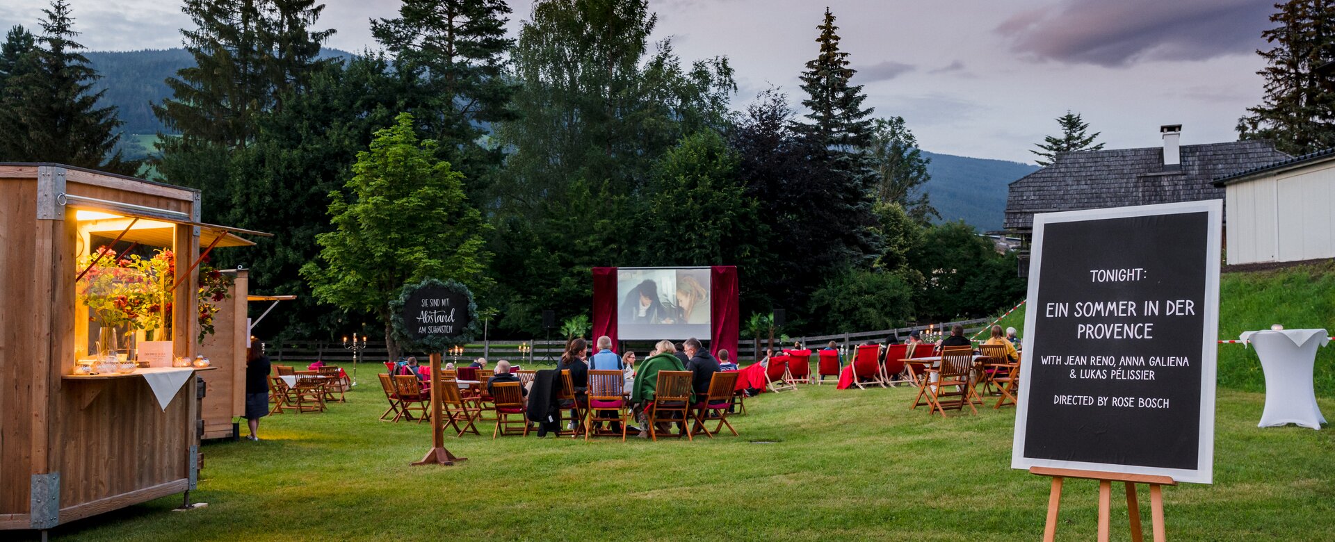 Gäste sitzen auf Stühlen beim Open-Air-Kino Licht.Spiele, vorne Tafel mit Filmtitel „Ein Sommer in der Provence“ | © Matthias Fritzenwallner