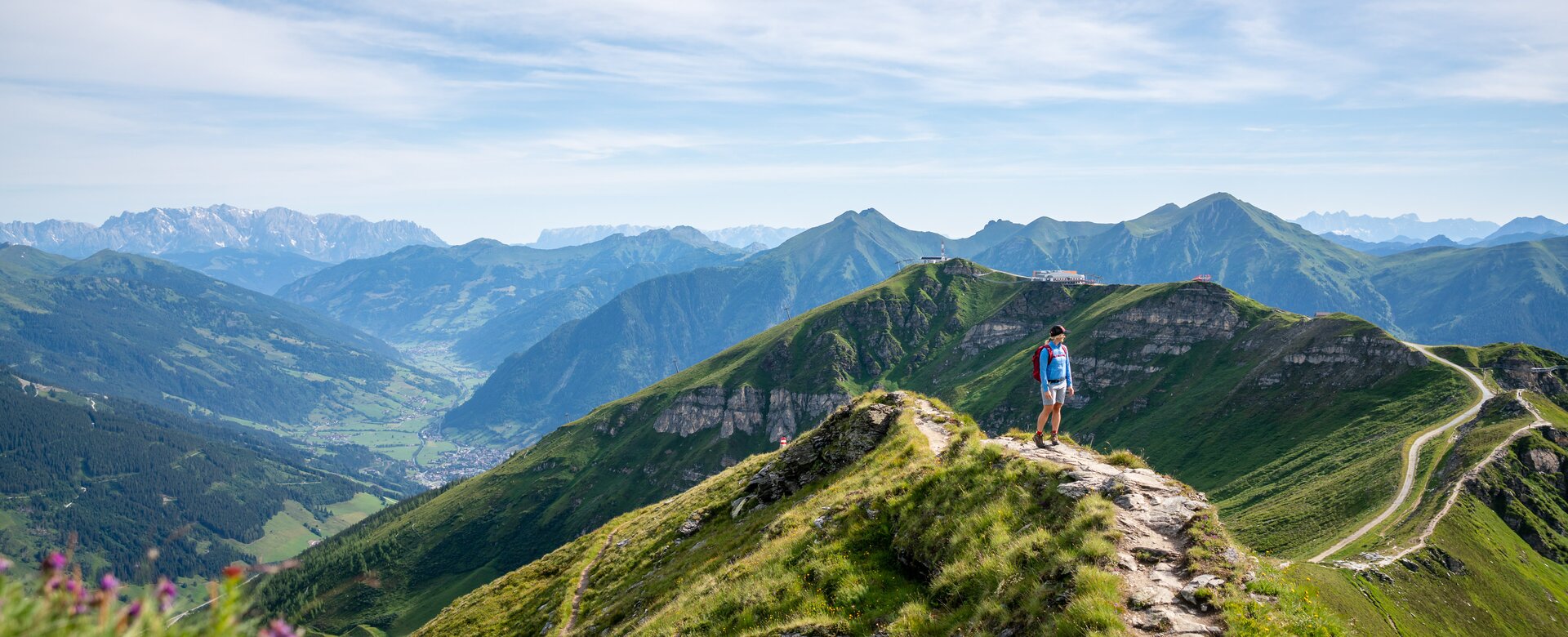 Hiker on a ridge trail at Stubnerkogel with a wide view over the green Gastein Valley and the surrounding mountain peaks | © Gasteinertal Tourismus GmbH, Christoph Oberschneider